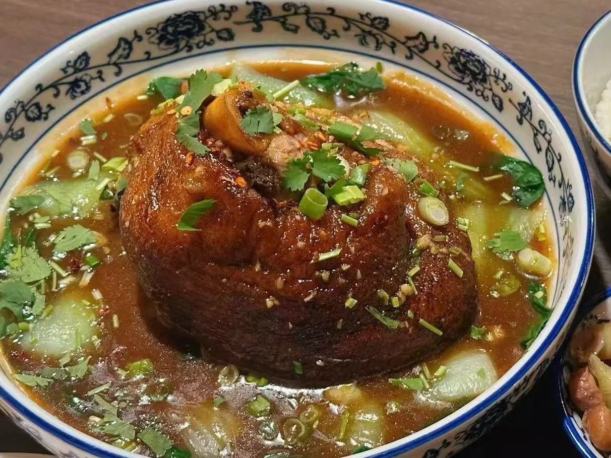 Large braised pork knuckle rice bowl simmered in thick savory brown sauce at 面滋味 Tasty Noodle House, a Chinese Restaurant in Plano