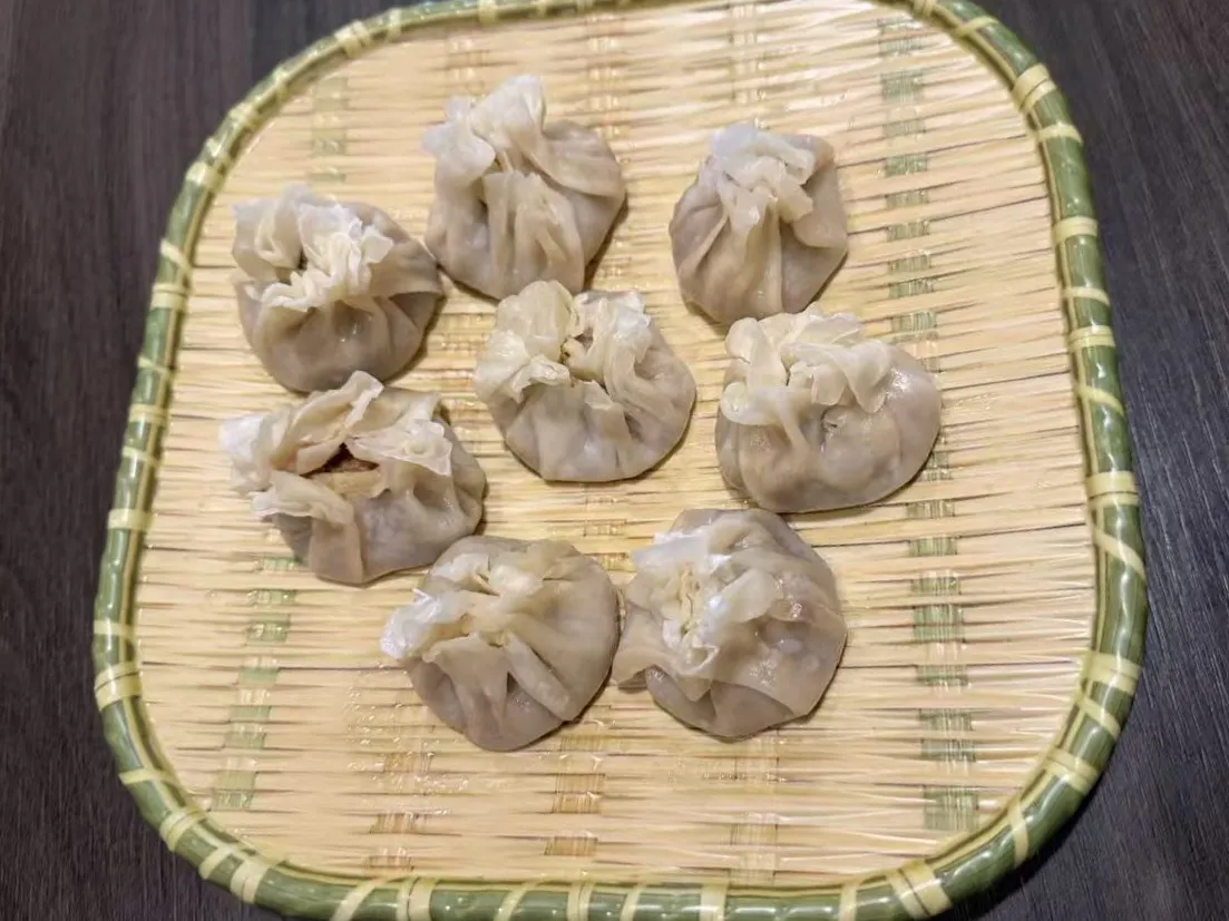 Eight handmade mutton siu mai dumplings laid on woven bamboo tray at 面滋味 Tasty Noodle House, a Chinese Restaurant in Plano